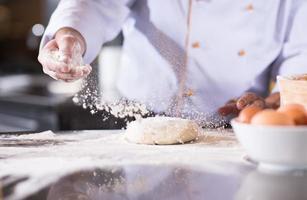 kock händer framställning deg för pizza foto