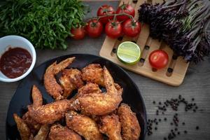 varm kött maträtter - friterad kyckling vingar på tallrik med sallad foto