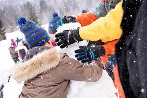 grupp av ung människor framställning en snögubbe foto