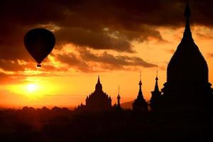 siluettpagod på soluppgång och ballong på bagan, myanmar foto