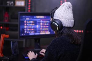 ung kvinna professionell banderoll och gamer med headsetet spelar uppkopplad video spel foto