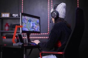 ung kvinna professionell banderoll och gamer med headsetet spelar uppkopplad video spel foto