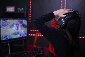 ung kvinna professionell banderoll och gamer med headsetet spelar uppkopplad video spel foto