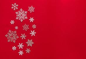 snö röd bakgrund. bakgrund med snöflinga, jul firande begrepp. platt lägga foto