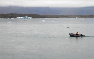 båt gående genom en lagun i island med en retirerar glaciär foto