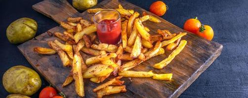 meny av franska frites eller friterad potatisar med tomat sås, rå potatisar på trä- bakgrund.top se foto