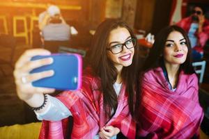två nära vänner gör selfie på caféet foto