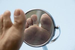 person ser på de enda av de fot i en spegel. foto