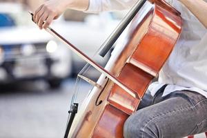 kille som spelar cello på gatan på sommaren foto