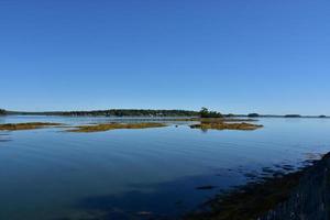 oländig havsstrand med visningar av liten franska ö foto