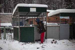 man är ser för mat i sopor. man utseende in i soptunna i vinter. fattig man på gata. foto