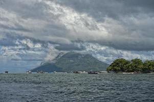 vulkan Bakom indonesiska fiskare by tropisk paradis foto