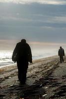 man och kvinna silhuett på strand på soluppgång foto