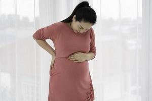 gravid kvinna känner ryggsmärta och obehag foto