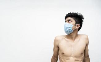 ung asain fitness modell sitter med en mask foto