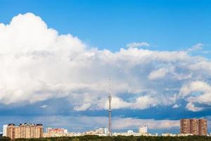 stor moln i blå himmel över stad med TV torn foto
