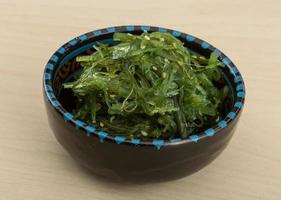 chuka sallad i en skål på trä- bakgrund foto