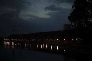 lampor på vid vattnet. sjö på natt i parkera. foto