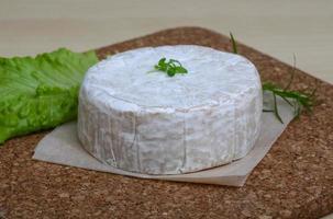 Camembert ost på trä- styrelse och trä- bakgrund foto