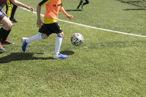 barns fotboll. boll spel. barn på sporter konkurrens i sommar. foto