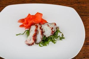 bläckfisk sashimi på de tallrik och trä- bakgrund foto
