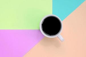 små vit kaffe kopp på textur bakgrund av mode pastell rosa, blå, korall och kalk färger papper foto