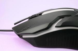 närbild av en svart gaming optisk mus på en rosa bakgrund foto