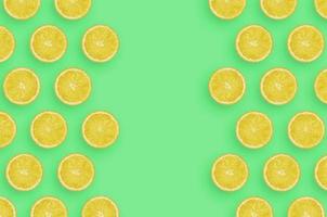 ram av gul citron- citrus- skivor på ljus grön bakgrund foto