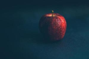 rött äpple på mörk bakgrund foto
