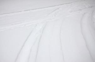 spår från de hjul av de bil på en snötäckt väg. farlig och hal vändning av de fordon foto