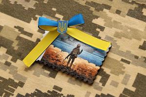 ternopil, ukraina - september 2, 2022 känd ukrainska poststämpel med ryska örlogsfartyg och ukrainska soldat som trä- souvenir på armén kamouflage enhetlig foto