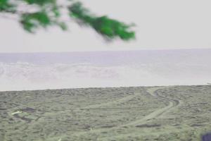 Foto av strand landskap på en solig dag, synlig strand sand och kust vattnen