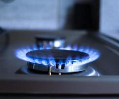 närbild av en blå brand från en kök spis. gas brännare med en brinnande flamma. ekonomi begrepp foto