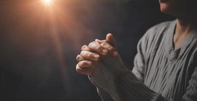 christ religion och kristendomen dyrkan eller be begrepp. kristen katolik kvinna är bön- till Gud i mörk på kyrka. bön person hand i svart bakgrund. flicka tro och tro i Jesus Kristus. foto