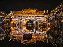 landskap se av hong bro och byggnad i de natt av Huang gammal stad .fågel Fenix gammal stad eller Huang grevskap är en grevskap av hunan provins, Kina foto