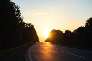 gryning över de väg godkänd genom de morgon- skog foto