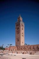 koutoubia moské minaret i marocko marrakesh och trädgårdar under solnedgång med blå himmel. inuti medina. foto