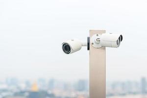 modern cCTV kamera mot stad och himmel bakgrund. övervakning, video spela in och övervakning begrepp foto