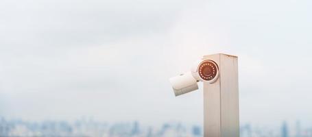 modern cCTV kamera mot stad och himmel bakgrund. övervakning, video spela in och övervakning begrepp foto