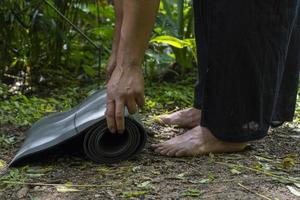 ung latin man arrangera hans yoga matta, inuti en skog på en enkel, direkt Kontakt med natur, mexico foto