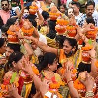 New Delhi, Indien 3 april 2022 - kvinnor med kalash på huvudet under jagannath-templet mangal kalash yatra, indiska hinduistiska hängivna bär jordkrukor som innehåller heligt vatten med en kokosnöt på toppen foto