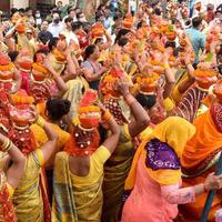 New Delhi, Indien 3 april 2022 - kvinnor med kalash på huvudet under jagannath-templet mangal kalash yatra, indiska hinduistiska hängivna bär jordkrukor som innehåller heligt vatten med en kokosnöt på toppen foto