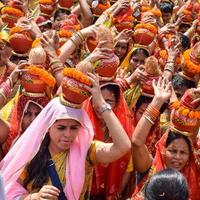 New Delhi, Indien 3 april 2022 - kvinnor med kalash på huvudet under jagannath-templet mangal kalash yatra, indiska hinduistiska hängivna bär jordkrukor som innehåller heligt vatten med en kokosnöt på toppen foto