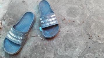 en blå sandal på en cement yta foto