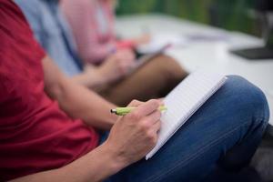 manlig studerande tar anteckningar i klassrum foto