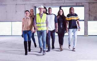 ung multietnisk företag människor gående genom oavslutat börja kontor foto