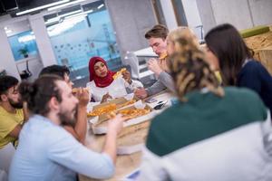 multietnisk företag team äter pizza foto