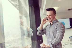 ung företag man tala på smart telefon på kontor foto