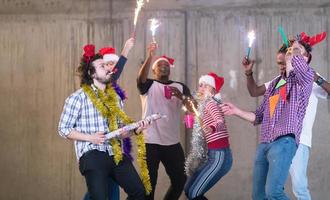 multietnisk grupp av tillfällig företag människor dans med sparklers foto