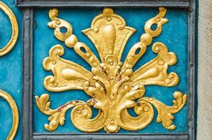detalj av blå dörr dekorerad med gyllene prydnad